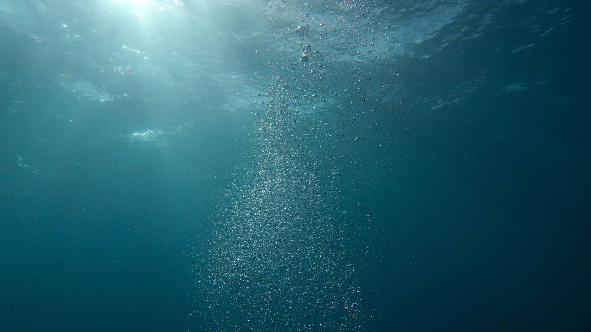 Scène sous-marine paisible avec de la lumière du soleil et des bulles s'écoulant dans l'océan
