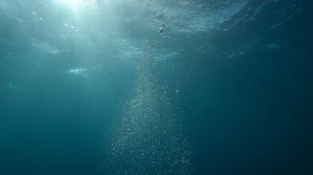 Scène sous-marine paisible avec de la lumière du soleil et des bulles s'écoulant dans l'océan