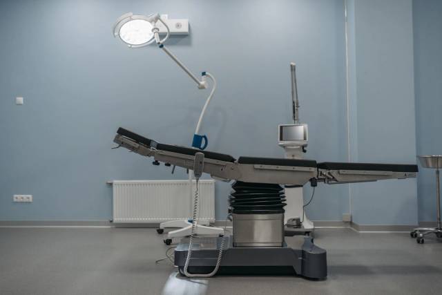 Table et éclairage dans une salle d’opération vide.