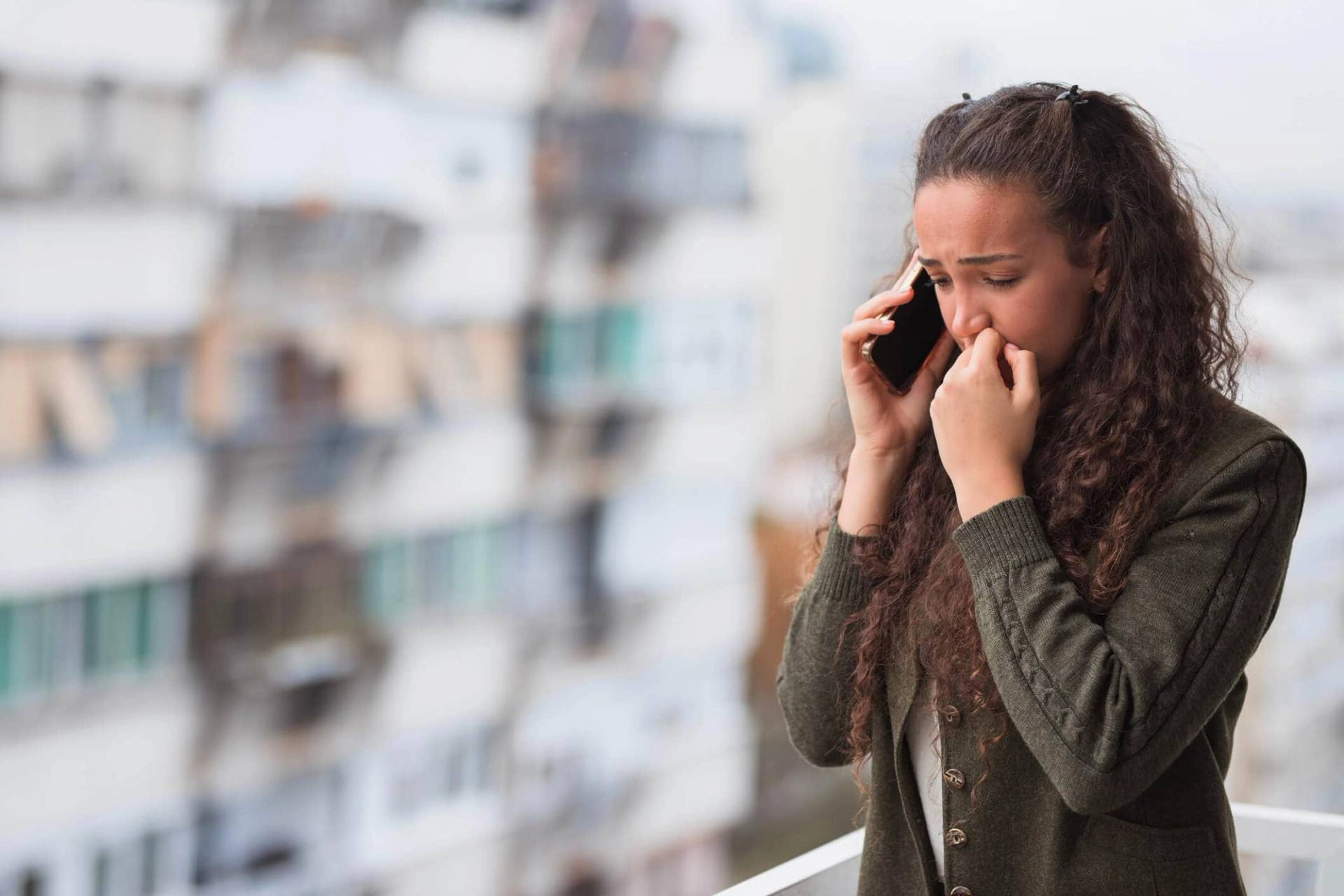 Femme seule assise sur un canapé illustrant l'autophobie et la peur d'être seul