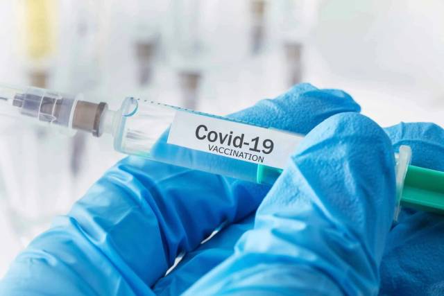Femme recevant une injection de vaccin Covid-19 par un professionnel de santé
