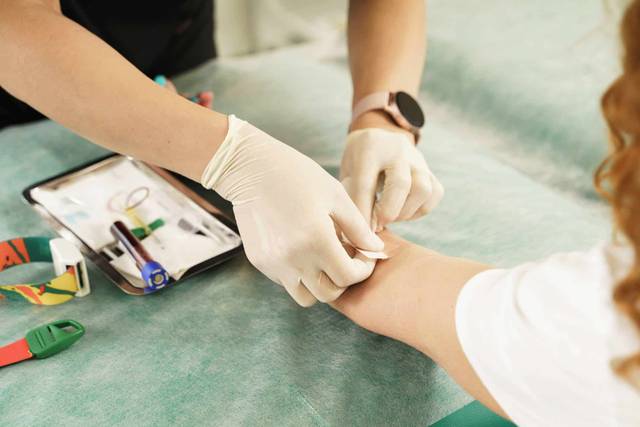 Médecin effectuant une prise de sang pour analyser le taux de gamma gt