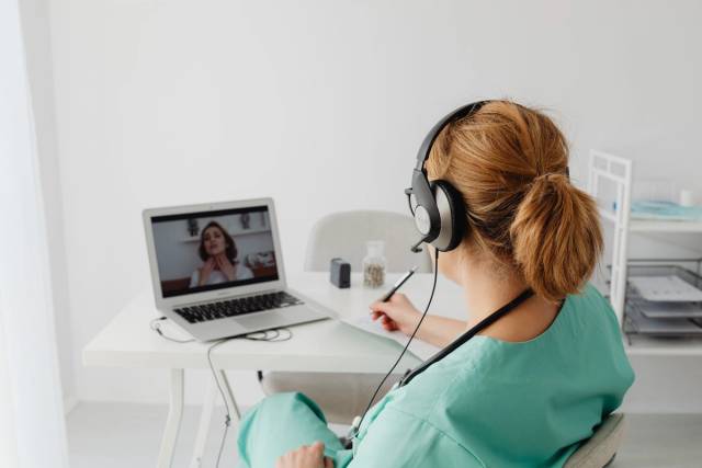 Une médecin consulte un patient virtuellement via appel vidéo, mettant en avant la technologie de télémédecine