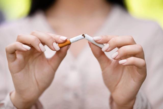 Mains brisant une cigarette.