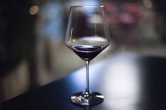 Un verre de vin rouge posé sur une table.