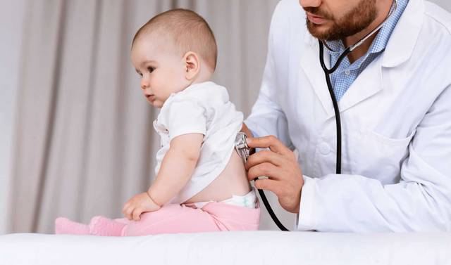 Médecin examinant un nourrisson atteint d'asthme lors d'une consultation pédiatrique