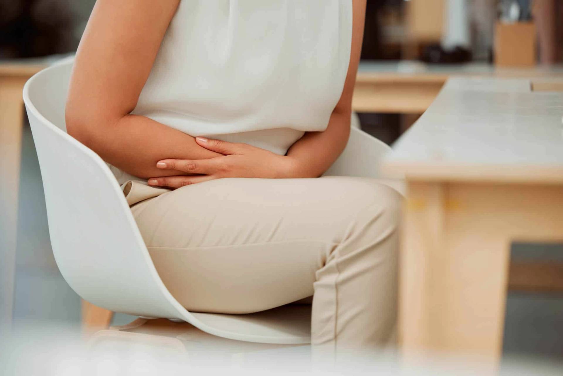 Une personne assise pose les mains sur son ventre.