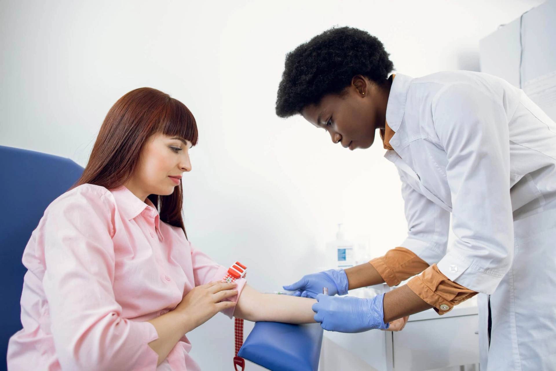Professionnel de santé effectuant une prise de sang à un patient lors d'une consultation médicale