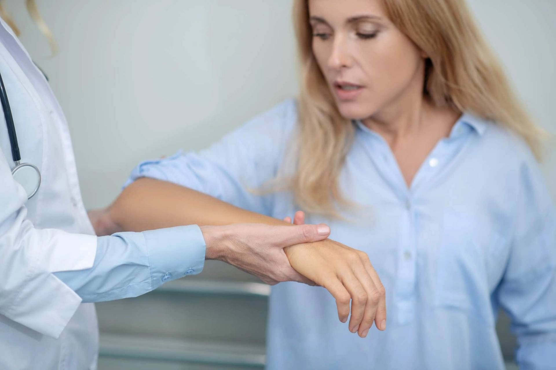 Médecin examinant l'avant-bras d'une patiente pour évaluer une douleur