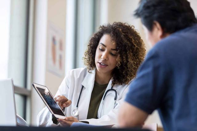 Médecin remplaçant en consultation avec un patient lors d'une visite médicale