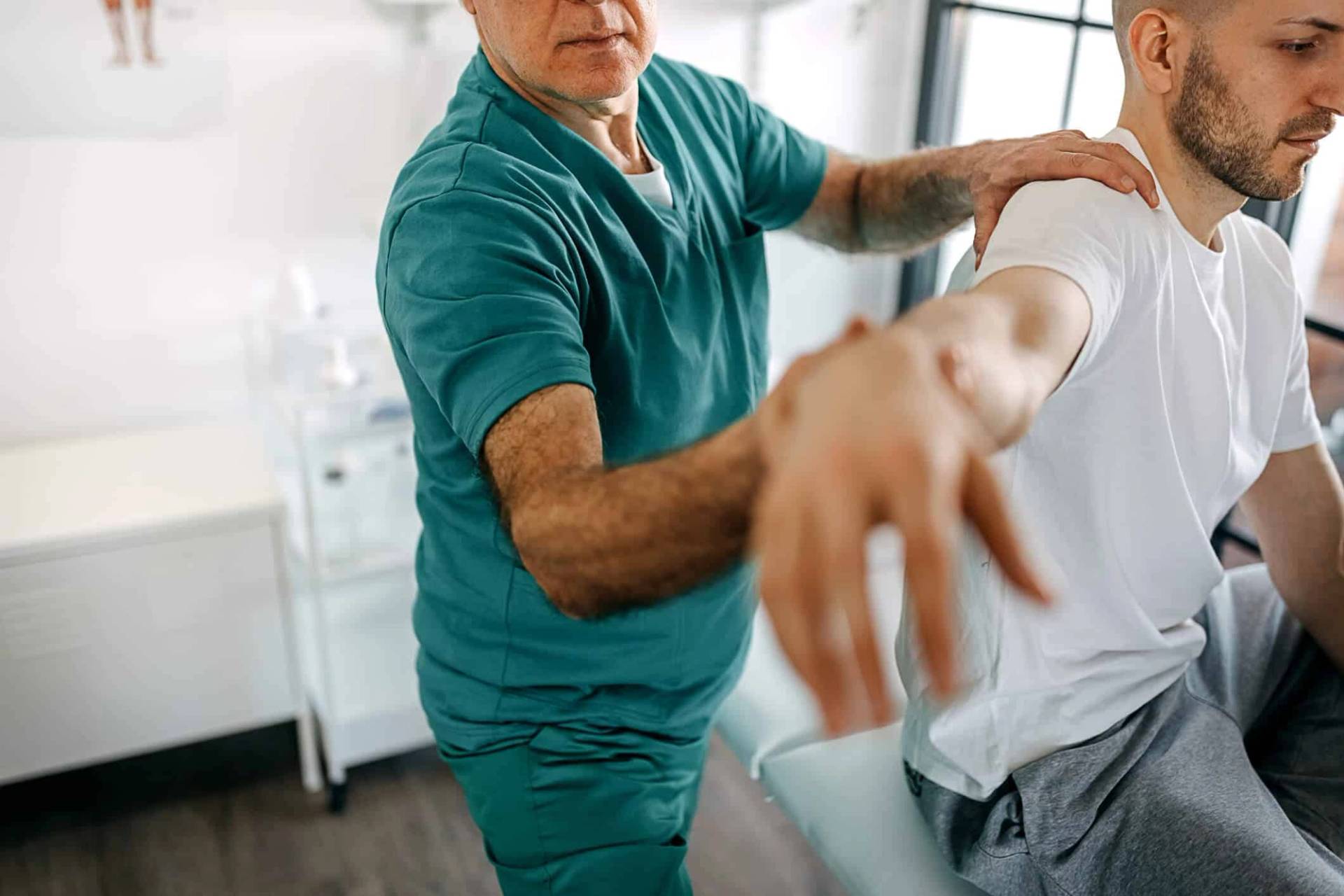 Médecin examinant le bras et l'épaule d'un patient pour évaluer une douleur au biceps