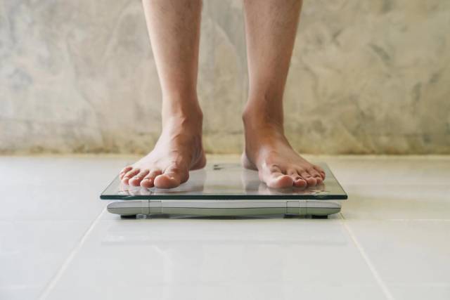 Pieds d’une personne sur une balance.