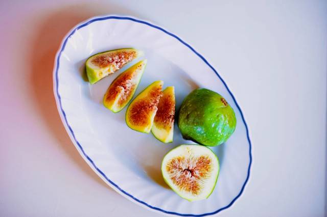 Vue aérienne de figues blanches de Cilento tranchées sur une assiette en céramique, mettant en avant la fraîcheur