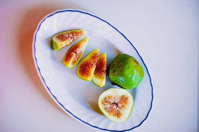 Vue aérienne de figues blanches de Cilento tranchées sur une assiette en céramique, mettant en avant la fraîcheur