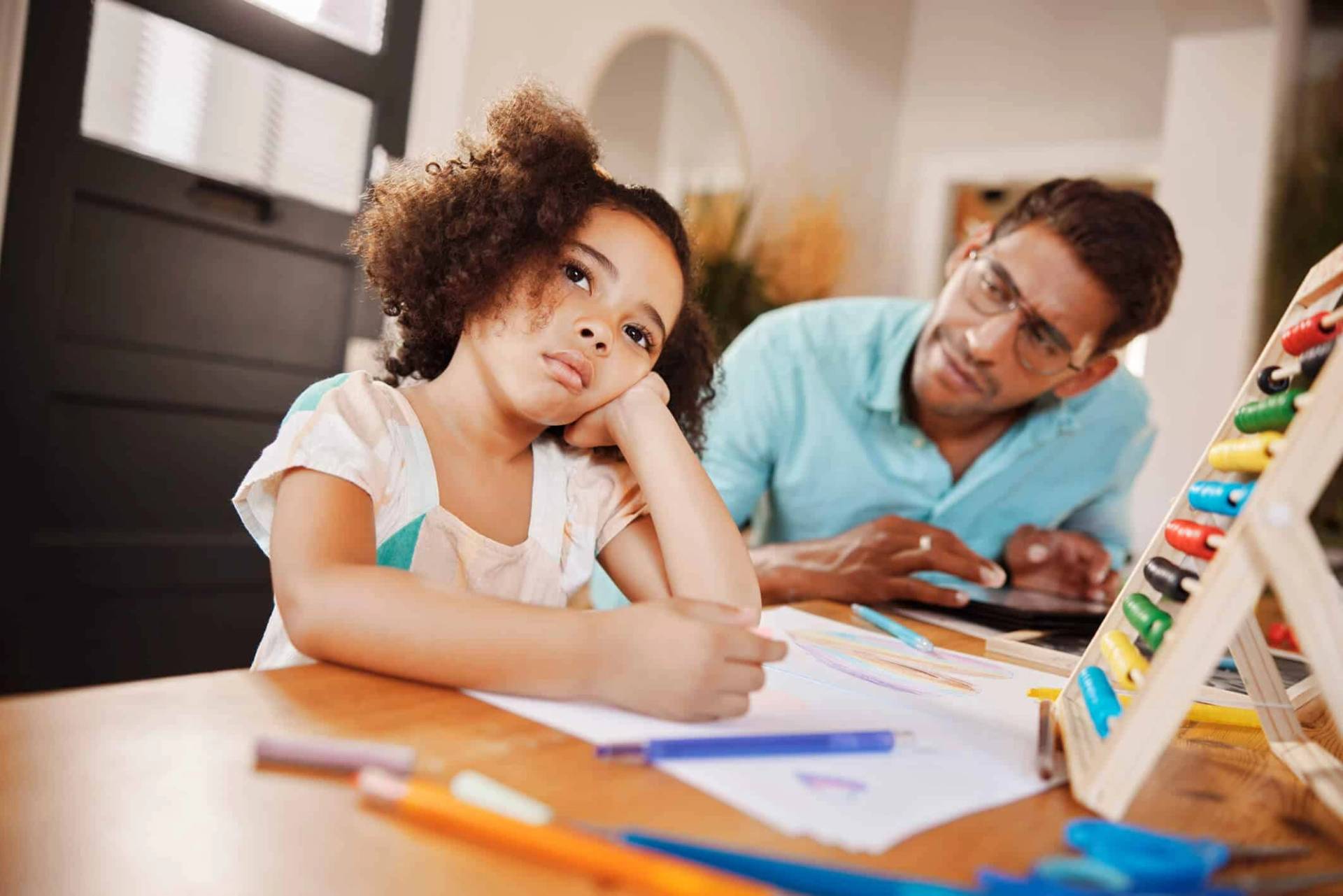 Adulte accompagnant une enfant à un bureau, près d’un boulier.