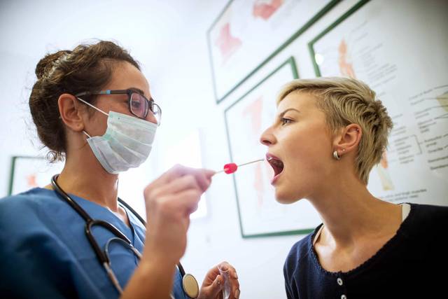 Professionnel de santé effectuant un test salivaire de dépistage du Covid-19 chez un patient
