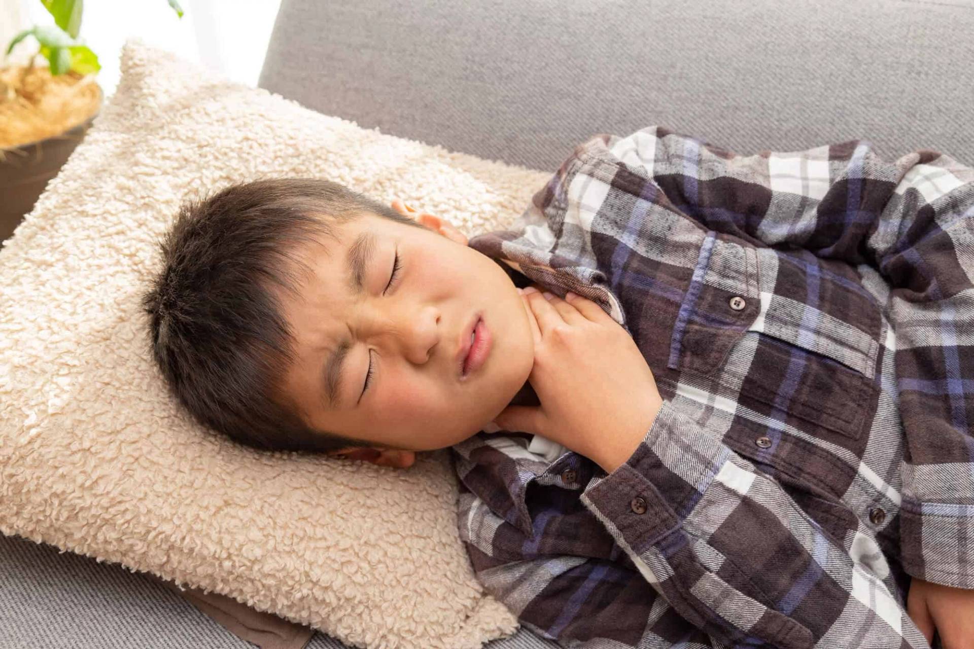 Enfant endormi, allongé sur un coussin.