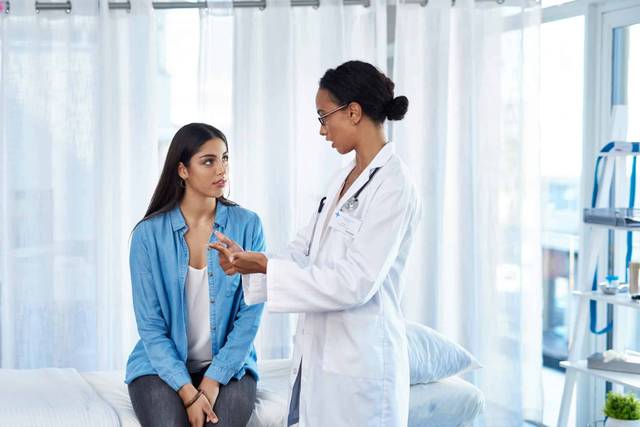 Femme en consultation médicale avec un professionnel de santé pour discuter des signes d'échec d'une IVG médicamenteuse