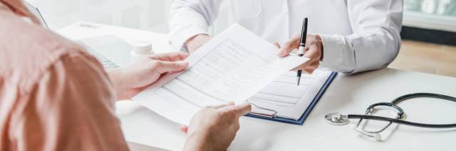 Médecin remplissant un certificat médical d'arrêt de travail lors d'une consultation