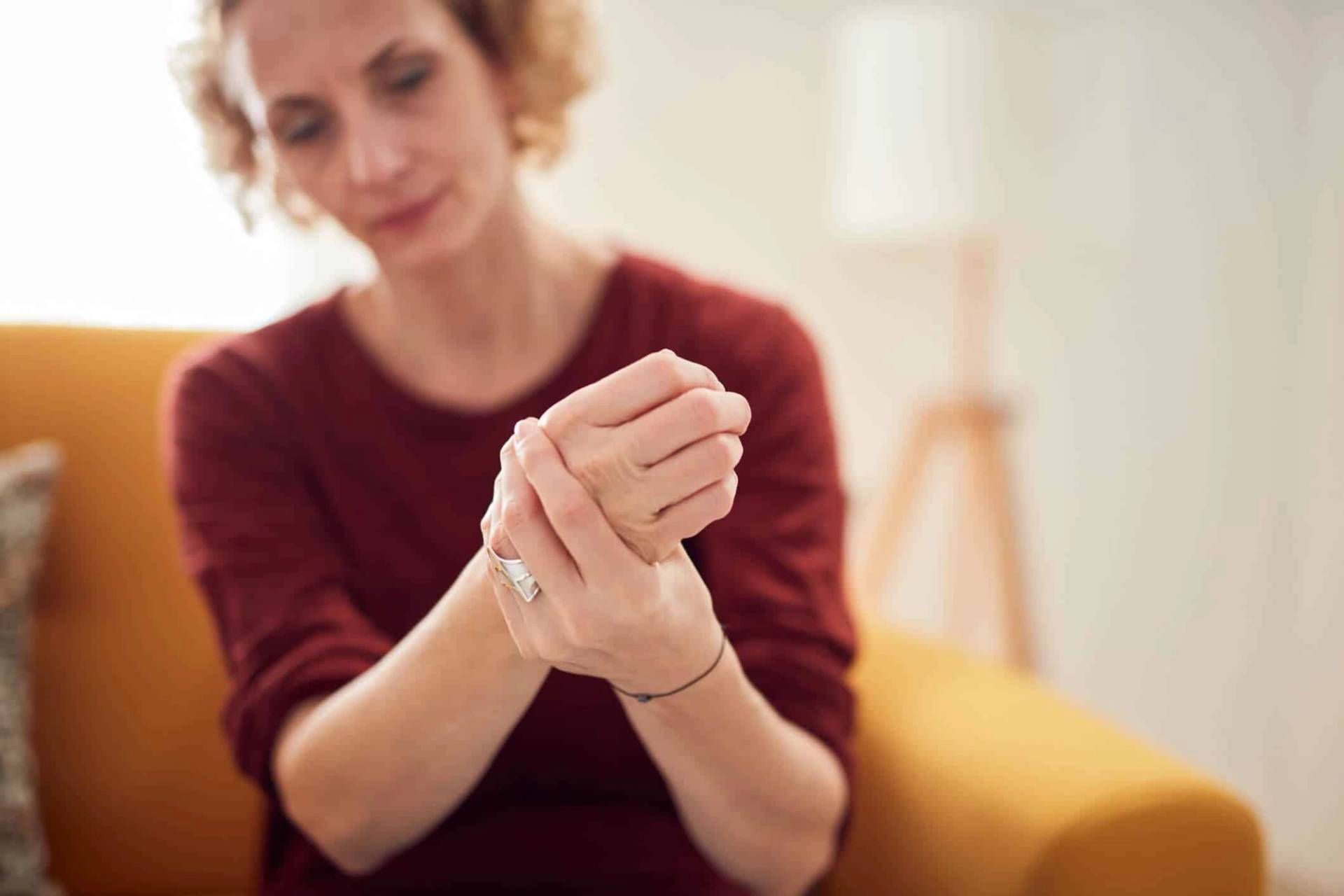 Femme tenant son poignet et sa main.