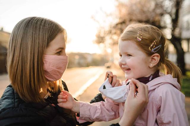 Adulte et enfant portant des masques en extérieur.