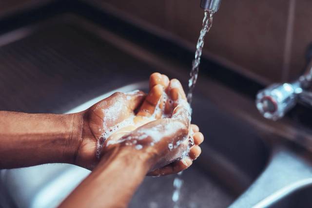 Lavage des mains au savon sous l’eau du robinet.