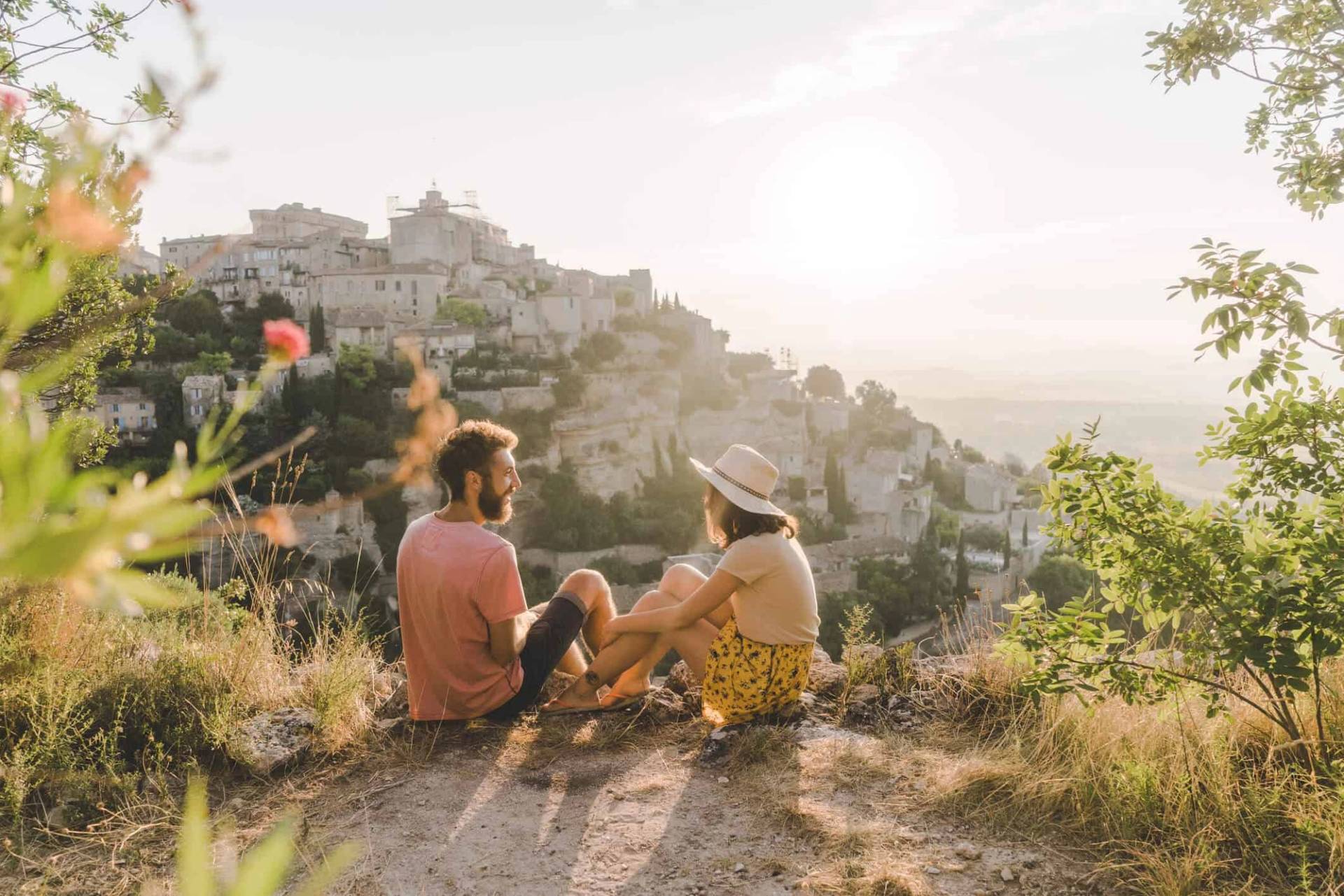 Deux personnes assises face à un paysage au soleil couchant.