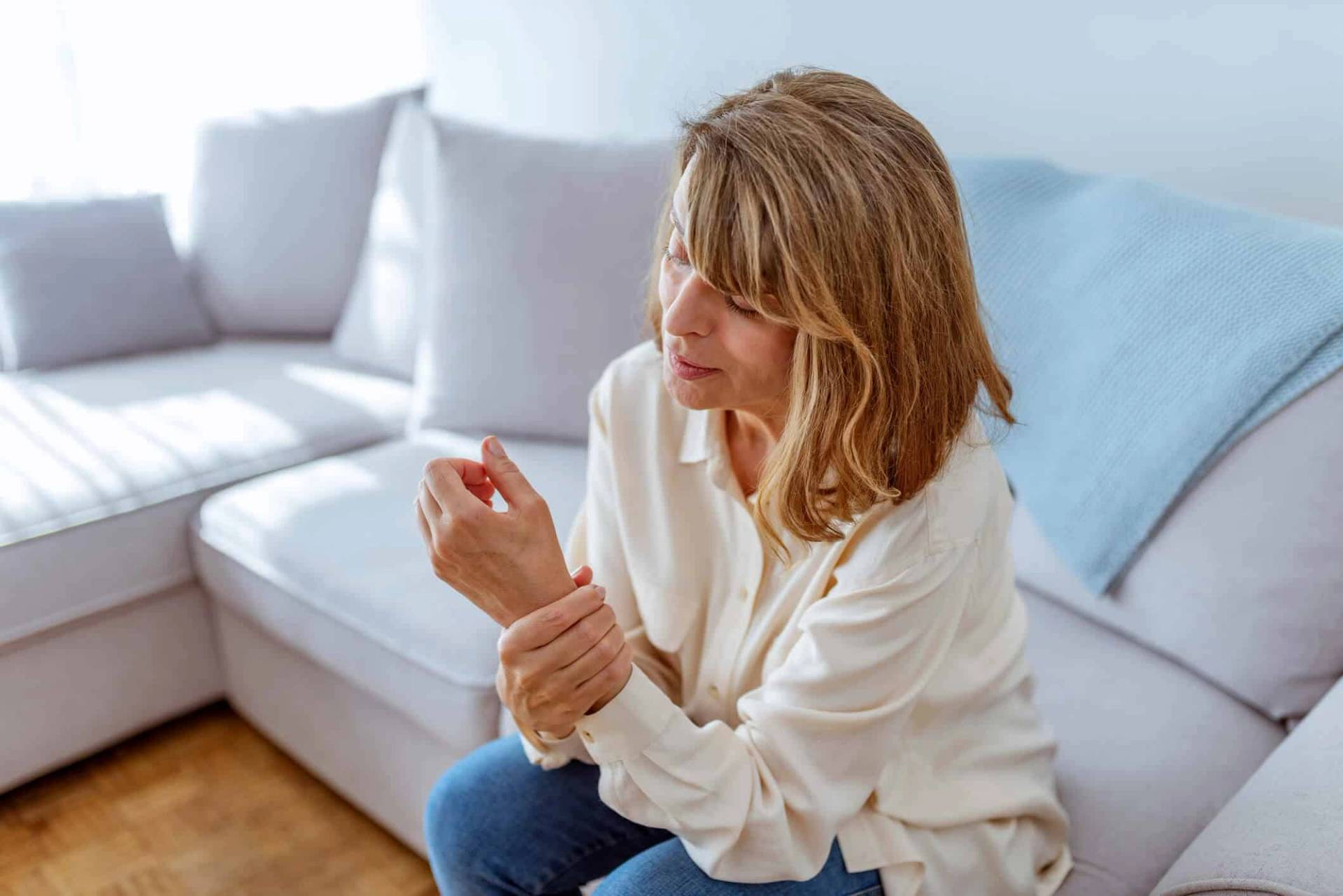 Femme assise tenant son poignet.