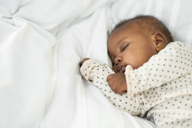 Nourrisson endormi dans un lit.