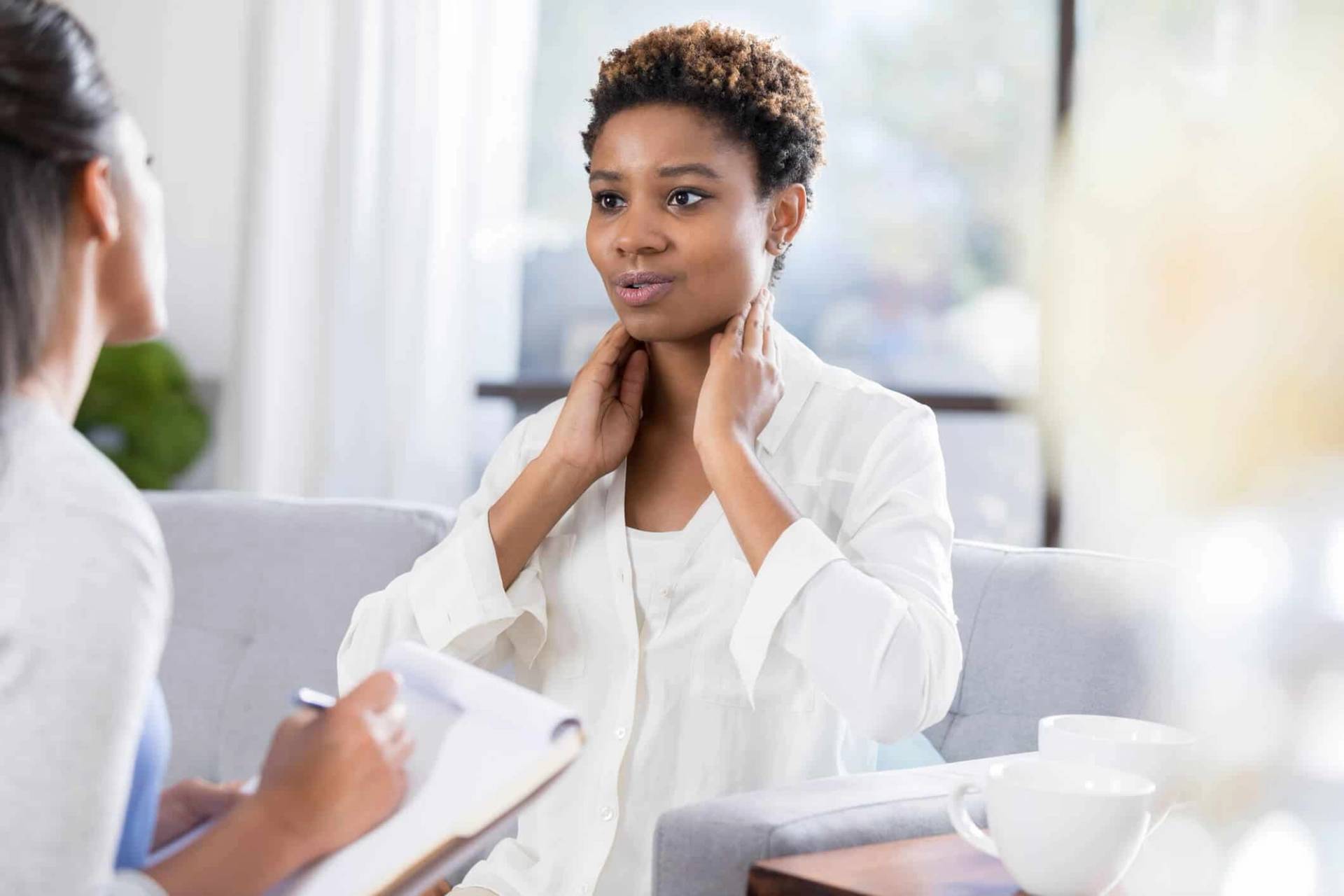 Femme montrant sa gorge à une professionnelle en consultation.