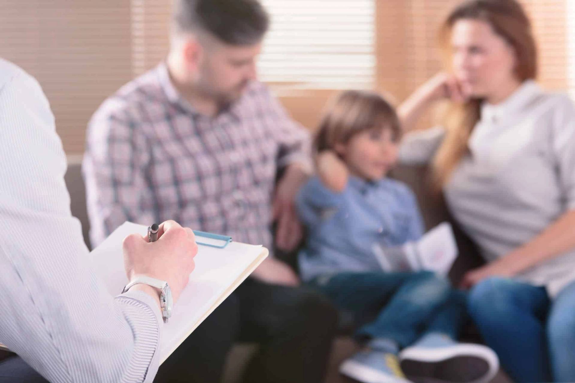 Groupe avec un enfant face à une personne prenant des notes.