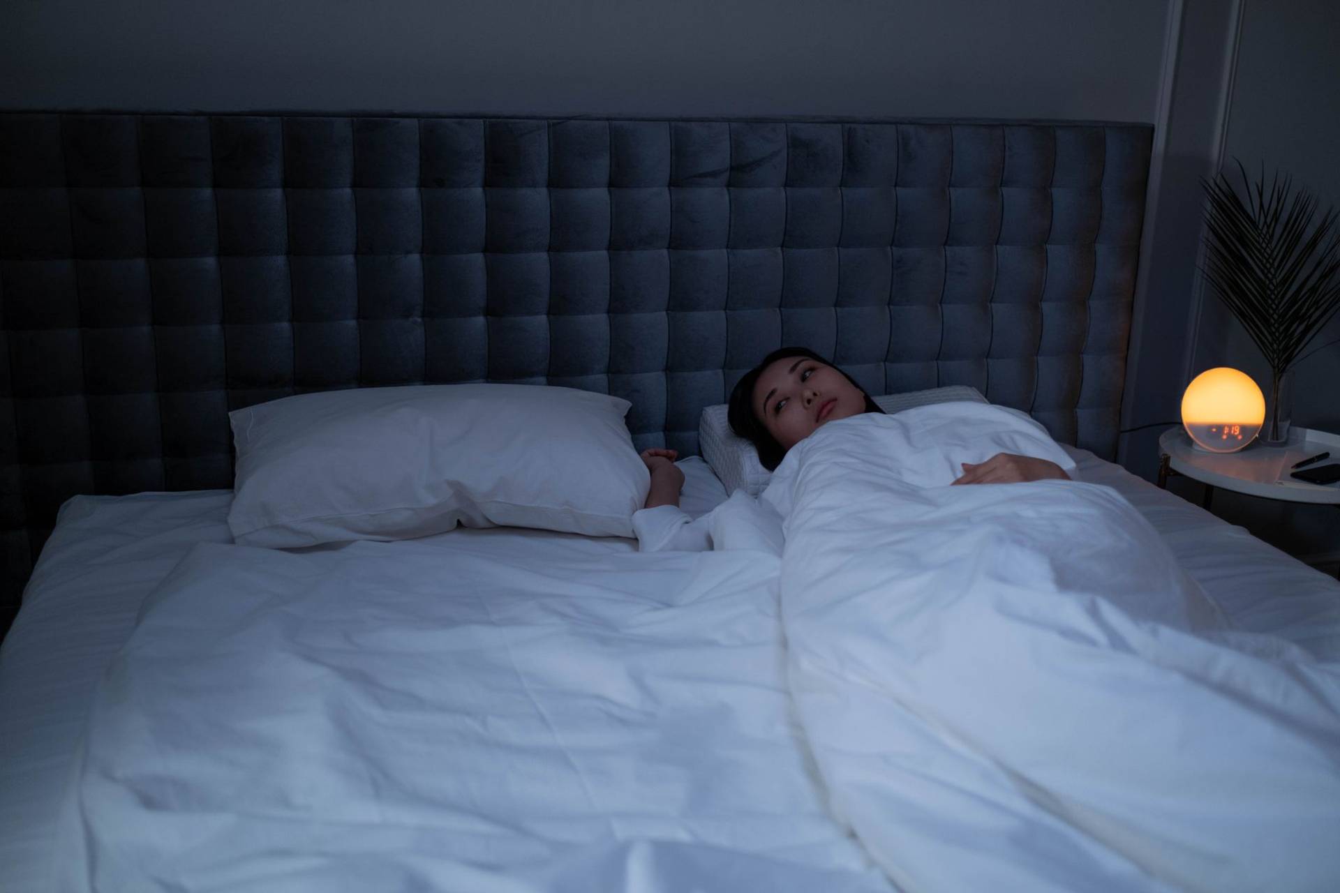 Personne éveillée dans un lit la nuit.