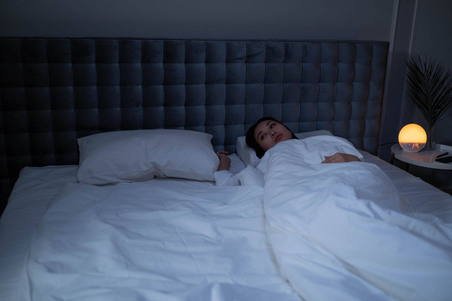 Personne éveillée dans un lit la nuit.