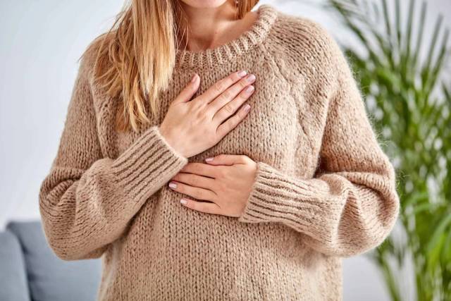 Personne posant ses mains sur le thorax et les côtes.
