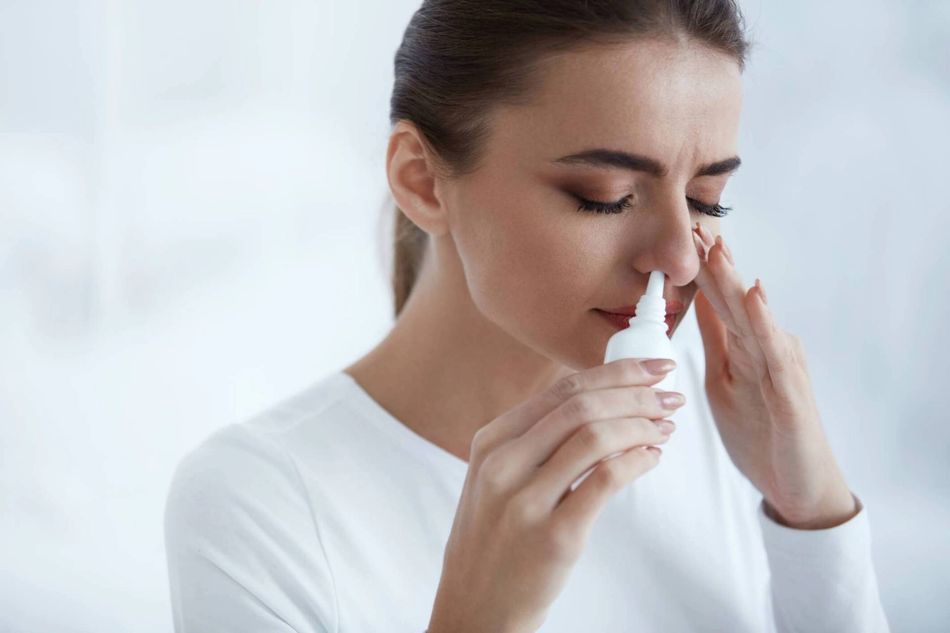 Femme utilisant un spray nasal.