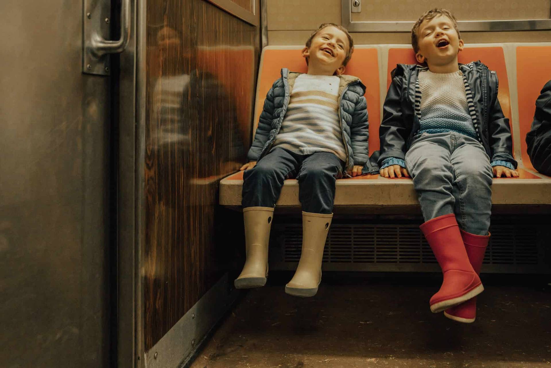 Deux enfants assis côte à côte dans un transport collectif.