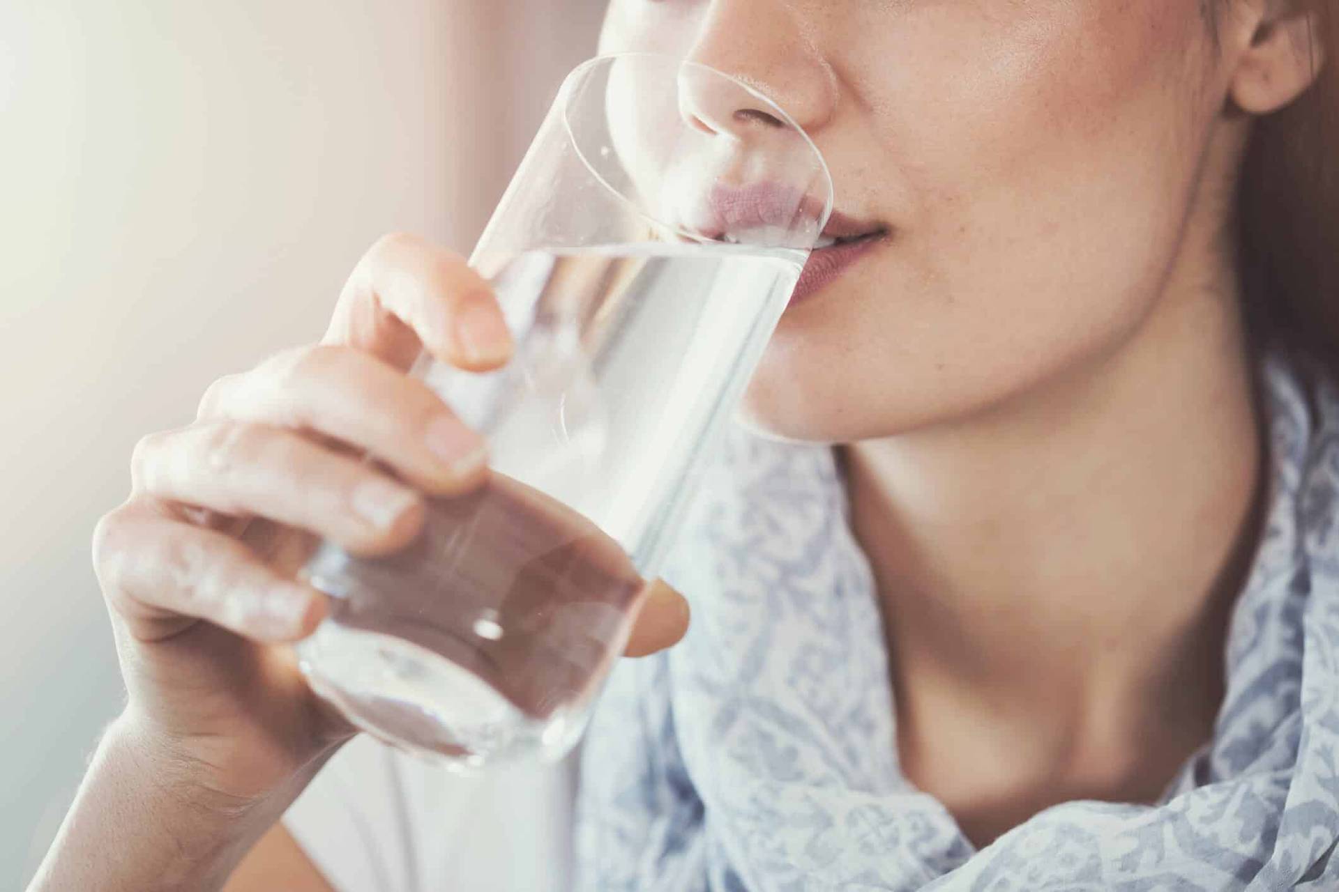 Femme buvant un verre d’eau.
