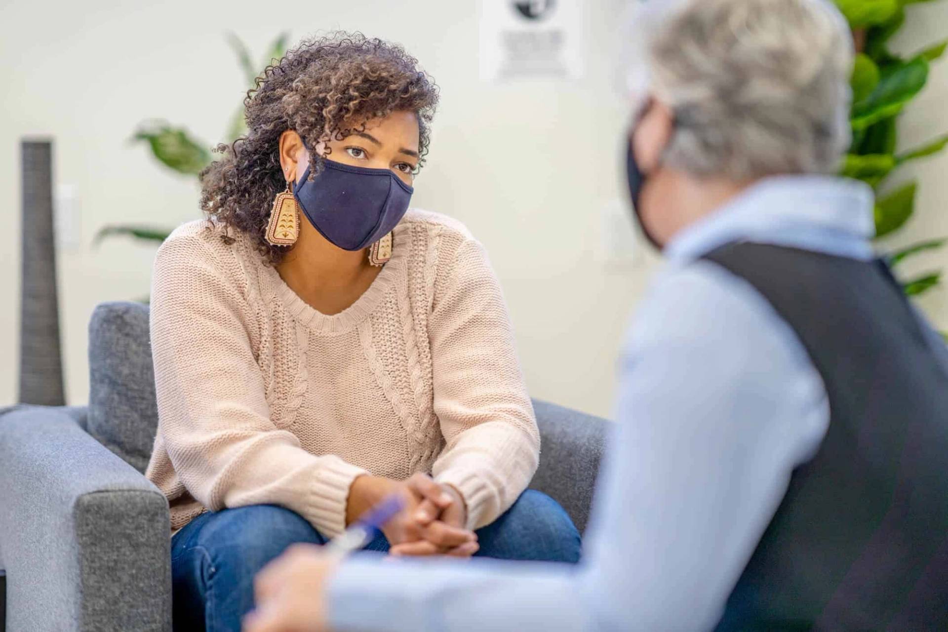 Deux personnes masquées assises en entretien.
