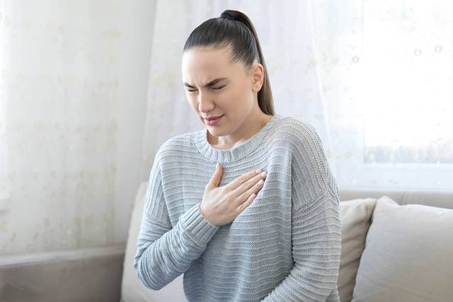 Femme souffrant d'asthme avec inhalateur lors d'une crise respiratoire