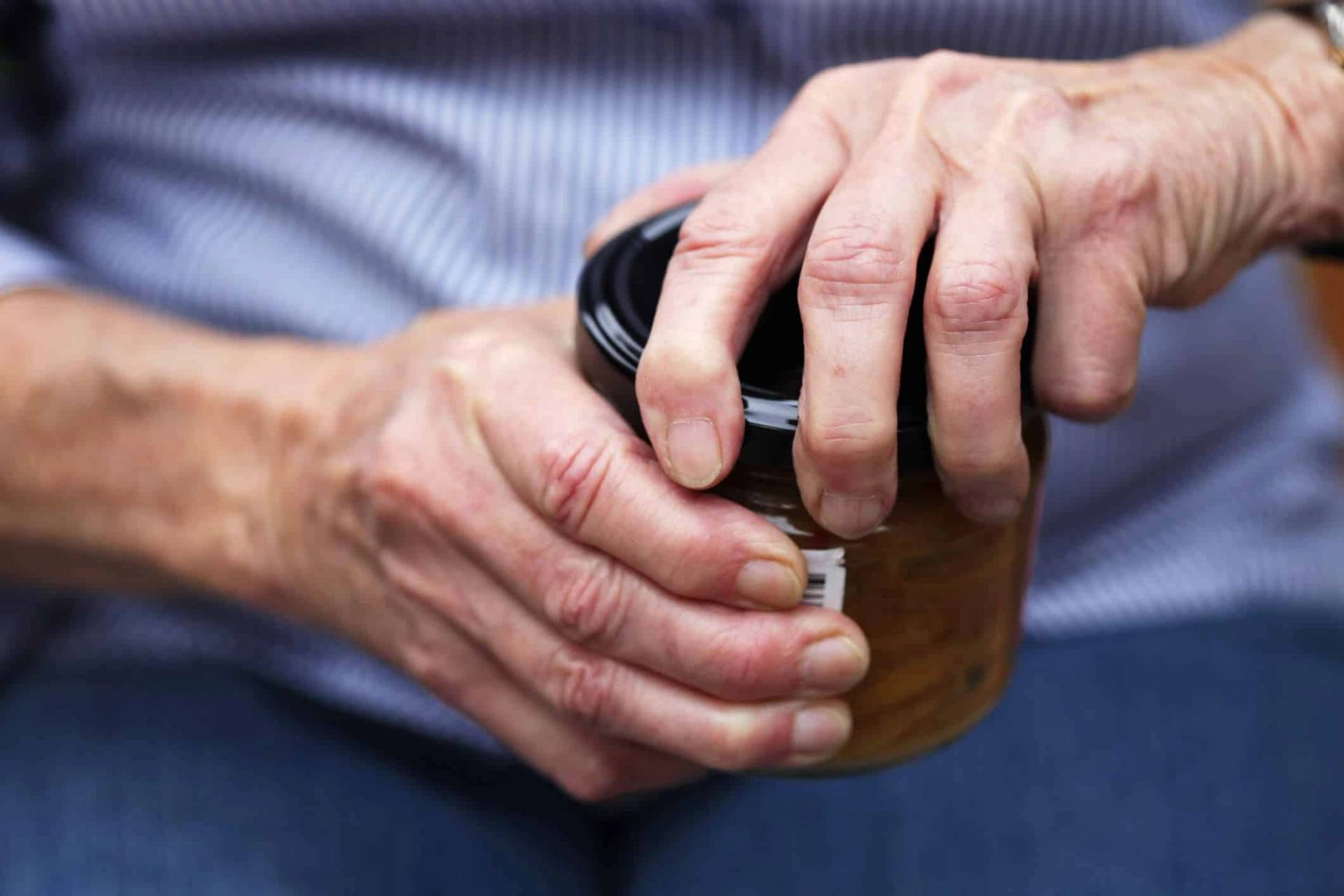 Mains ouvrant le couvercle d’un bocal.