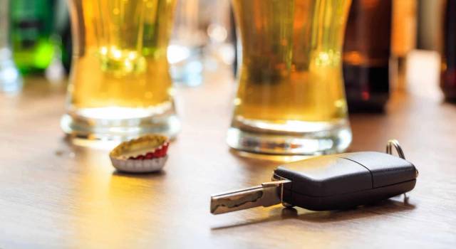 Clé de voiture posée près de verres de bière.