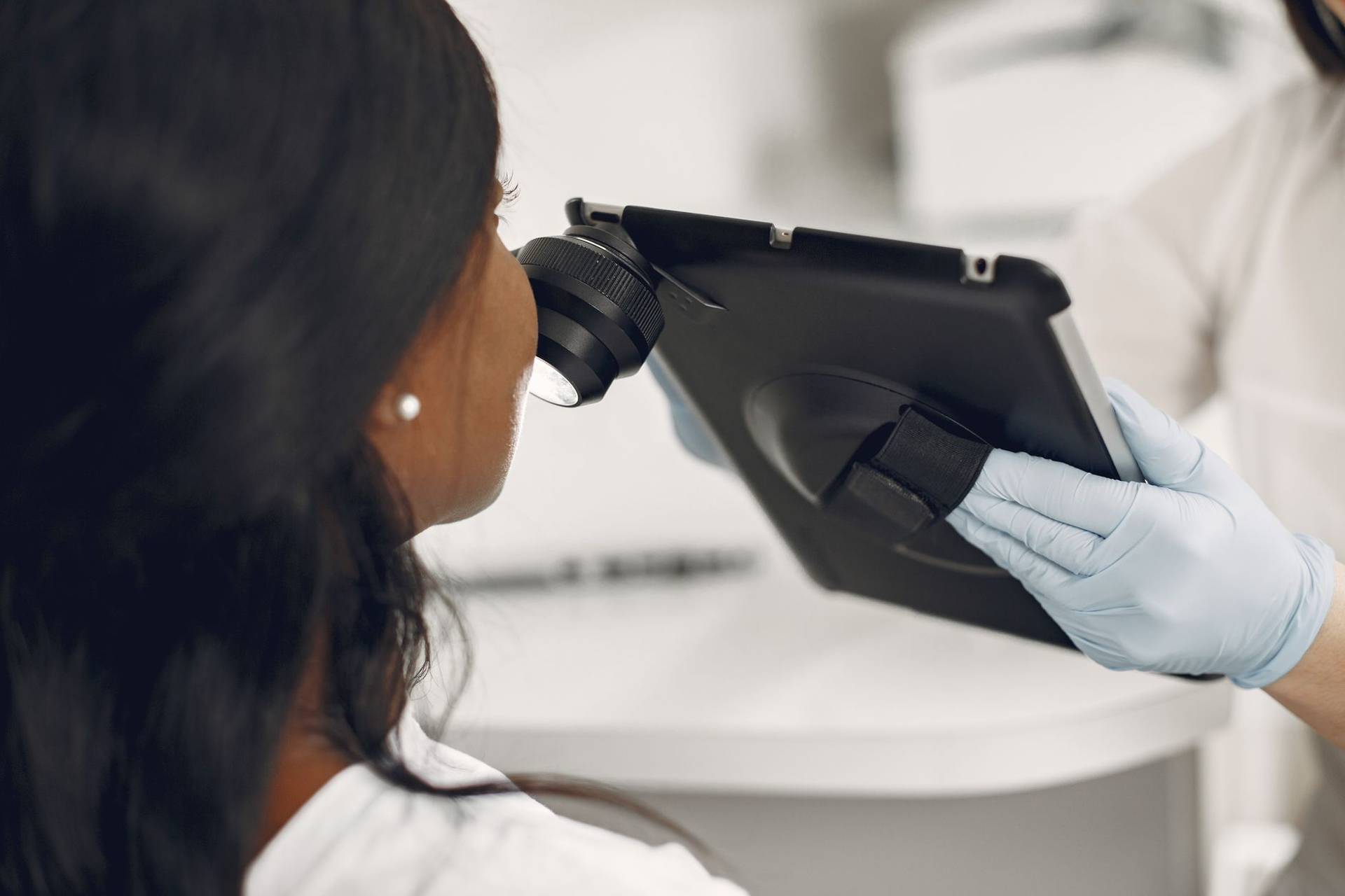 Dermatologue examinant la peau d’une patiente avec un dermatoscope numérique