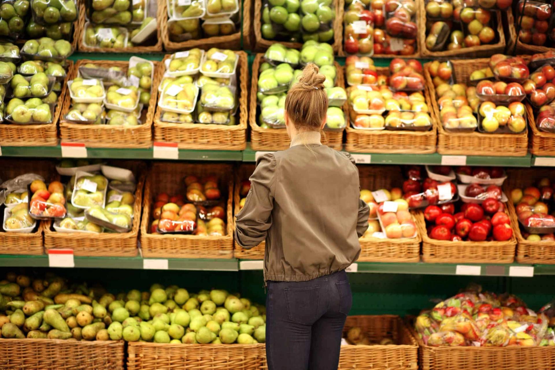 Personne choisissant des fruits et légumes dans un magasin.
