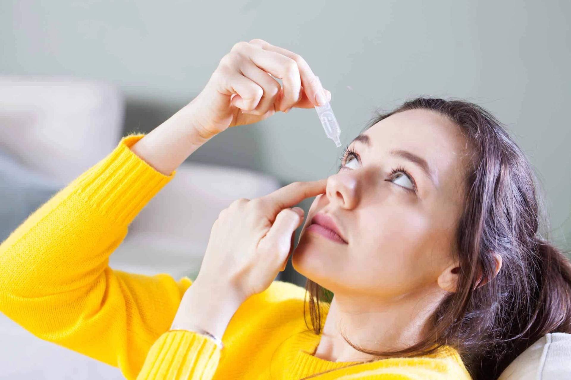 Femme se mettant des goutes dans les yeux
