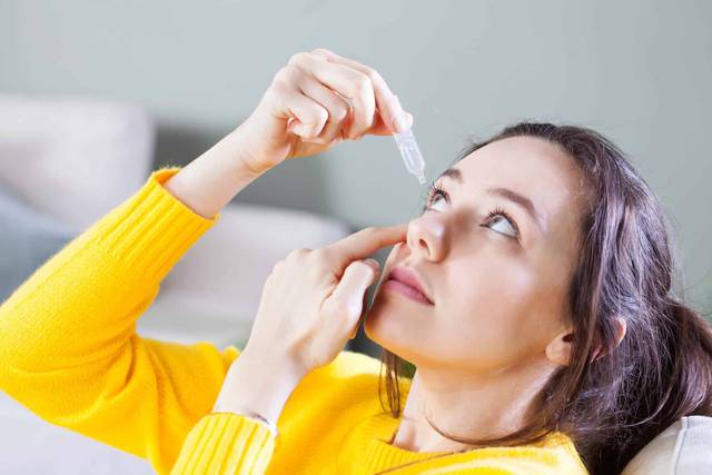 Femme se mettant des goutes dans les yeux