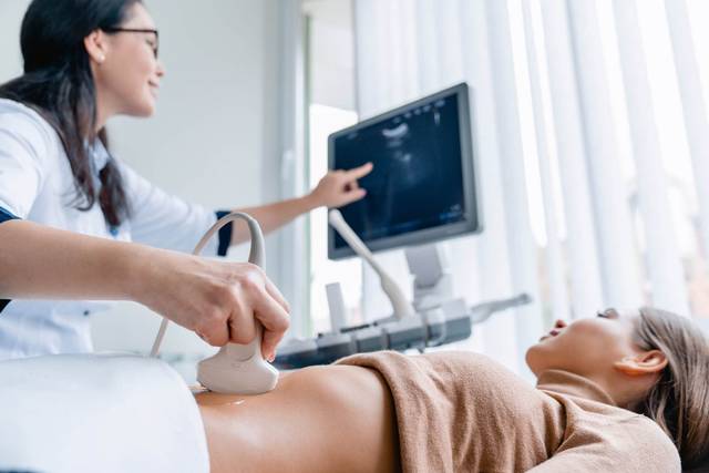 Professionnelle réalisant une échographie abdominale.