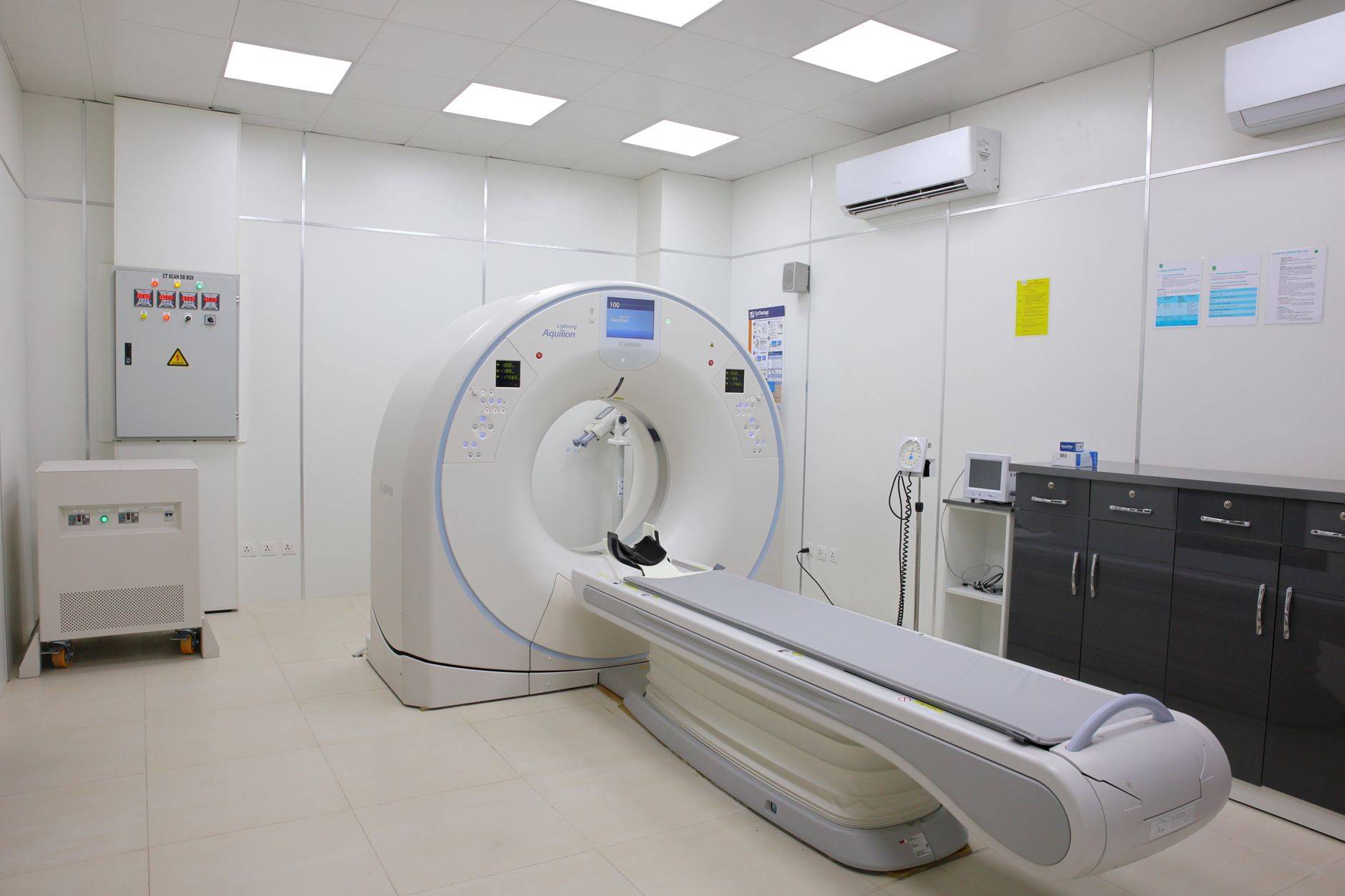 Scanner médical et table d’examen dans une salle d’imagerie.