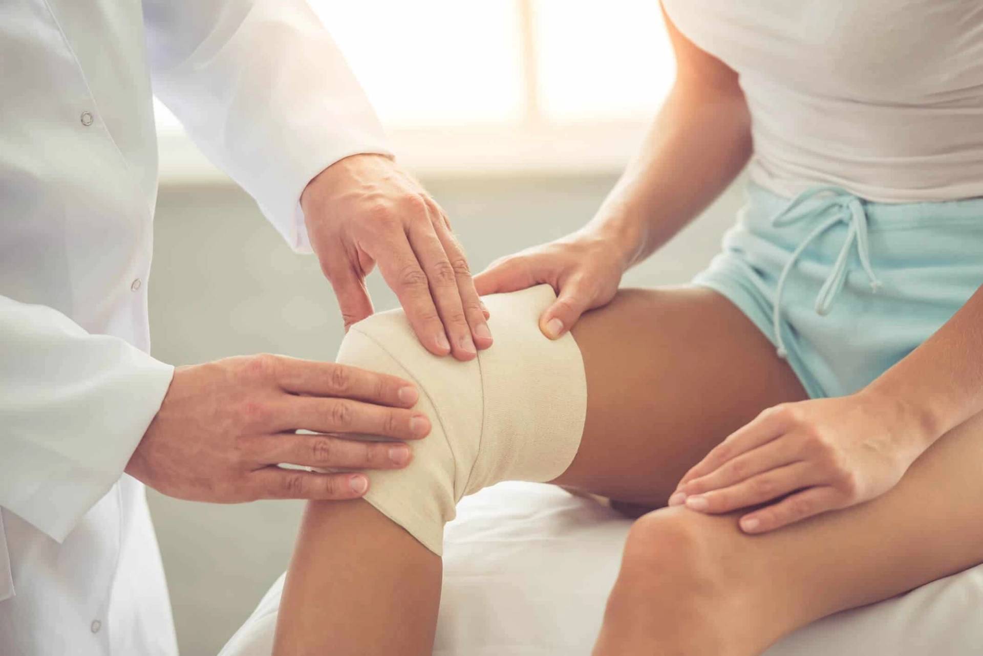 Professionnel posant un bandage autour du genou.