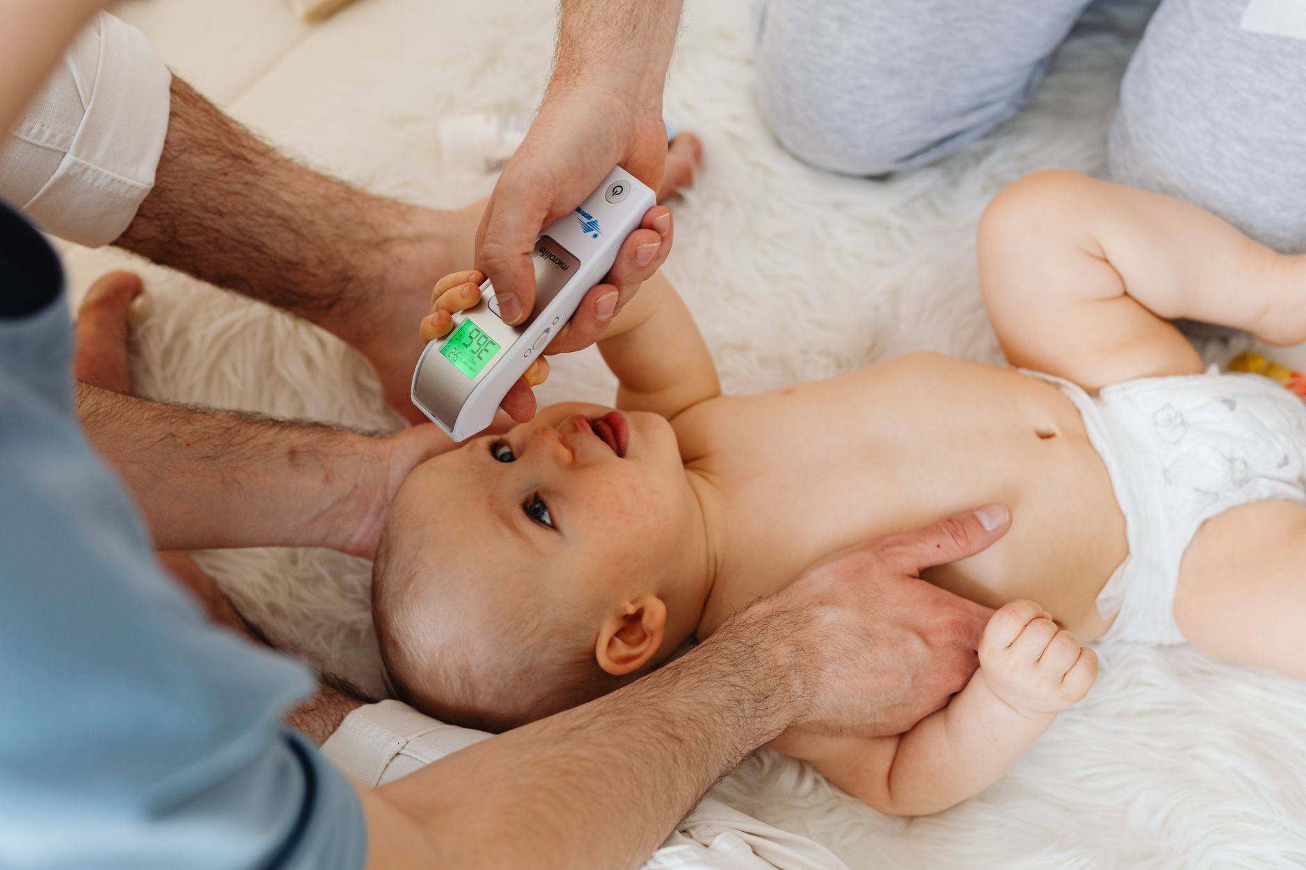 Mesure de la température d’un bébé avec un thermomètre frontal.