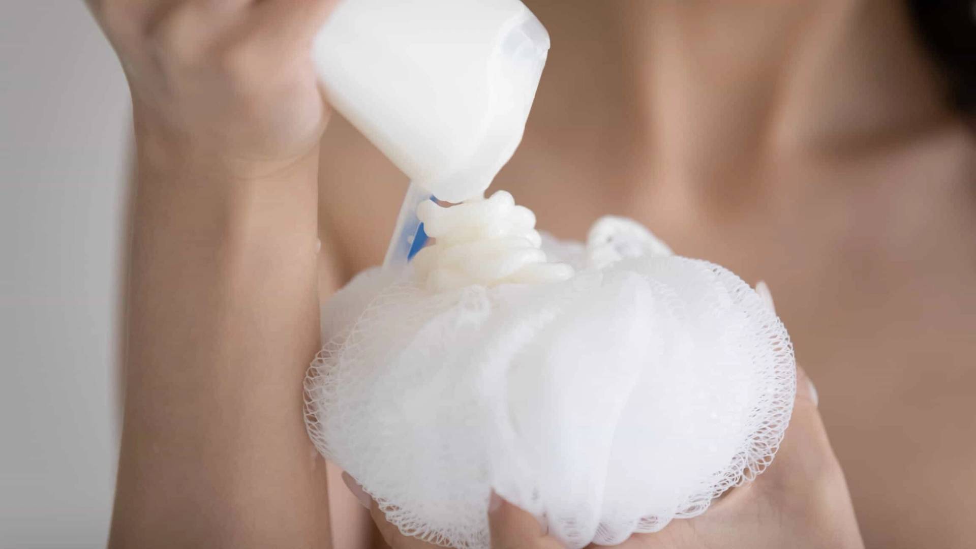 Personne versant un produit liquide sur une fleur de douche.